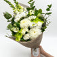 A bouquet of white flowers held in hand against a white background, wrapped by jute and made by a florist in Melbourne.