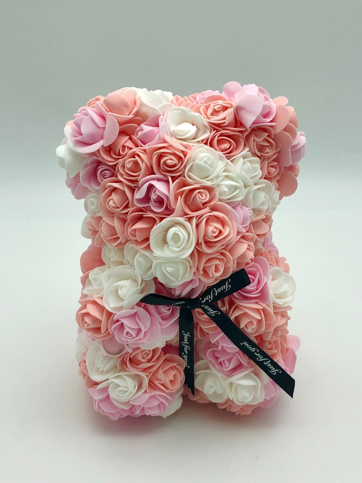 This is an image of a teddy bear made from roses in various shades of pink, white, and peach, available in Melbourne.