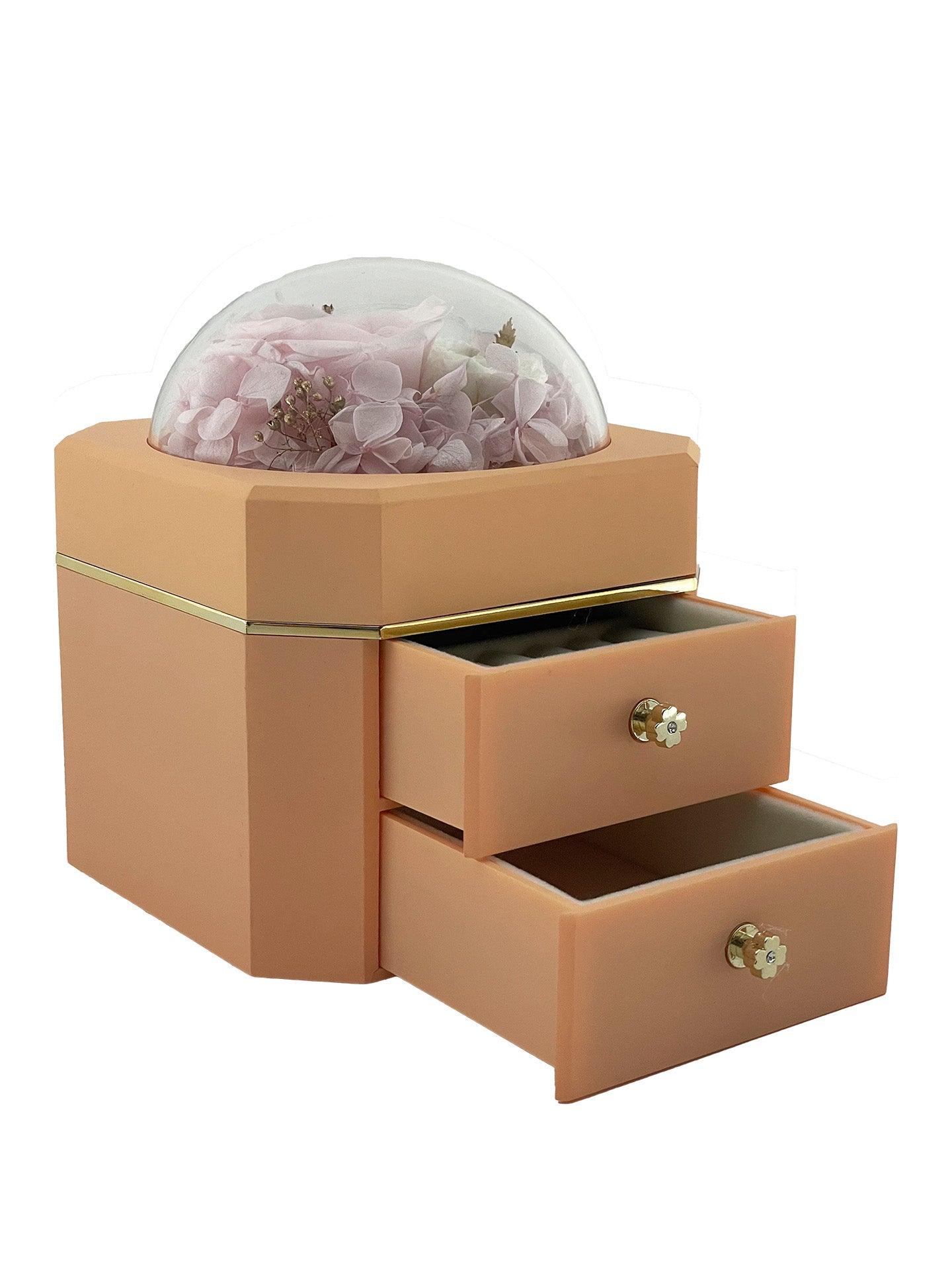 The beautiful duo-drawer jewellery box with a pinkish-tan finish complements the elegance of this preserved flower arrangement. It features a stunning pink rose, two delicate white flowers, and pink hydrangea petals. Same-day delivery is available in Melbourne, VIC, Australia.