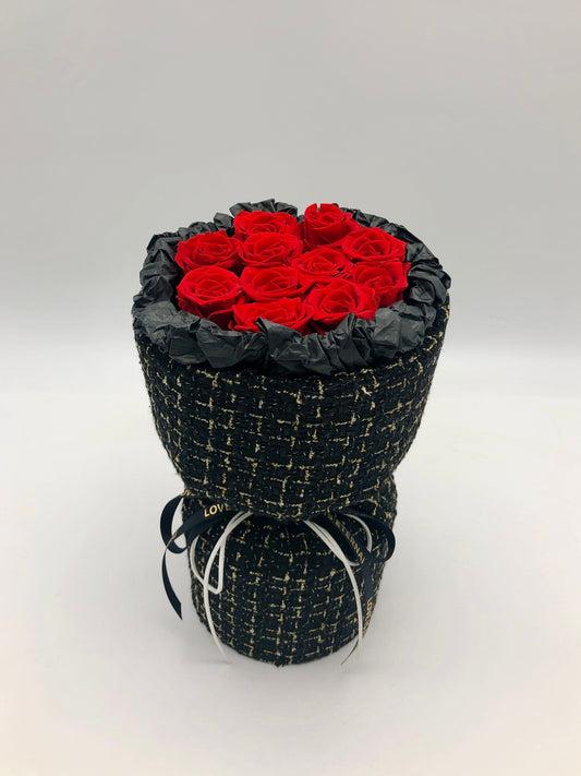A bouquet of preserved red roses in a black box with white pattern of lines and dots. Available in Flowers Express Co in Melbourne.