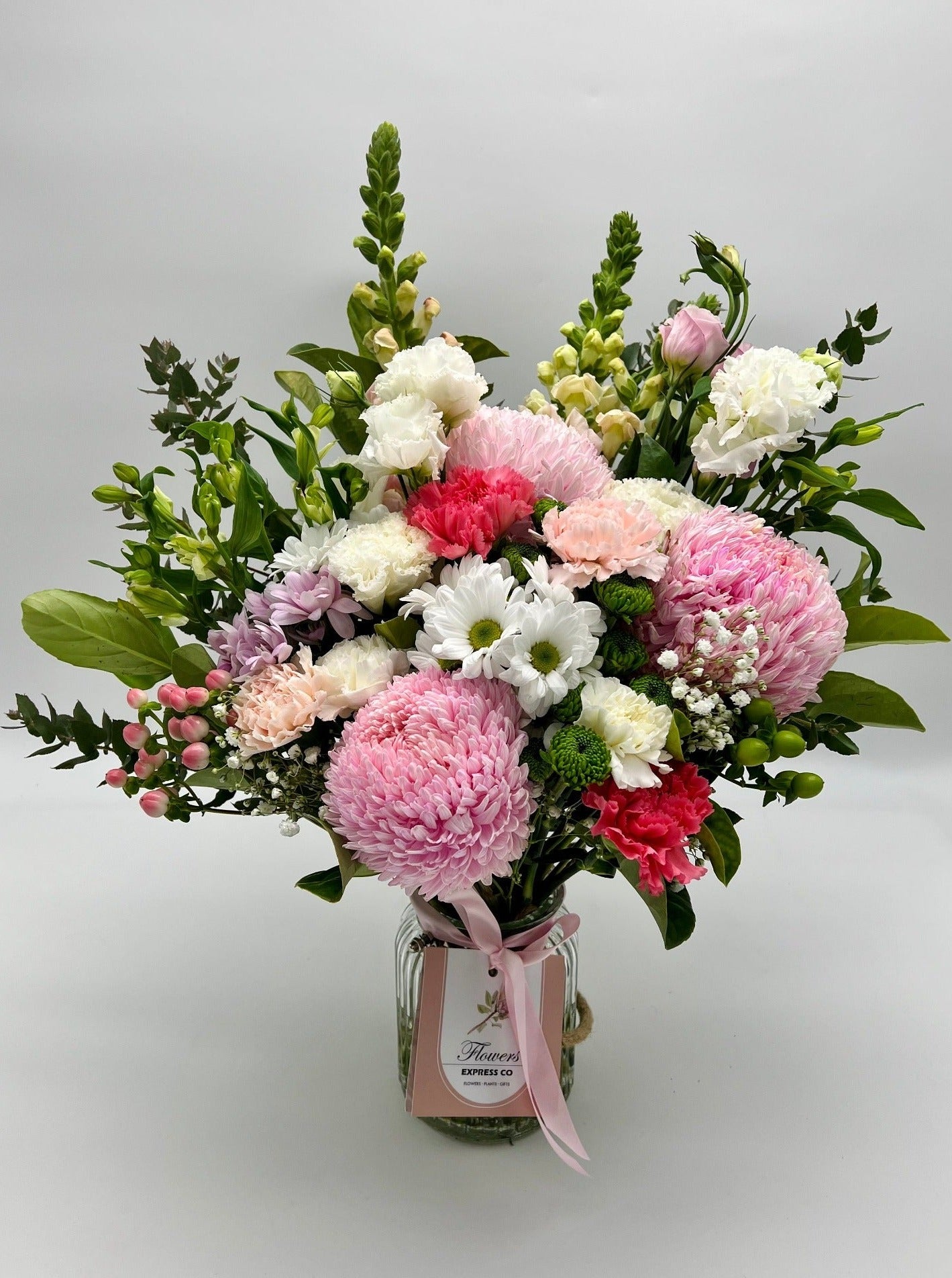 A large bouquet of fresh flowers in shades of pink and white, handcrafted in Melbourne by Flowers Express Co florists and presented in bottles.