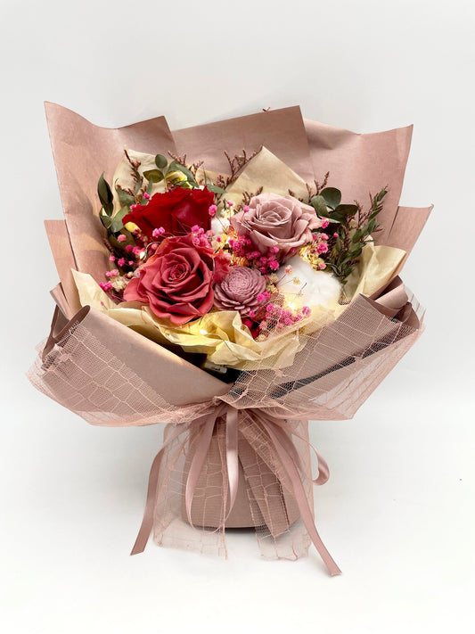 A luxurious bouquet with deep red and soft roses, accented by delicate pink blooms and greenery, elegantly wrapped in brown and pink paper with a satin ribbon, arranged by Flowers Express Co in Melbourne.