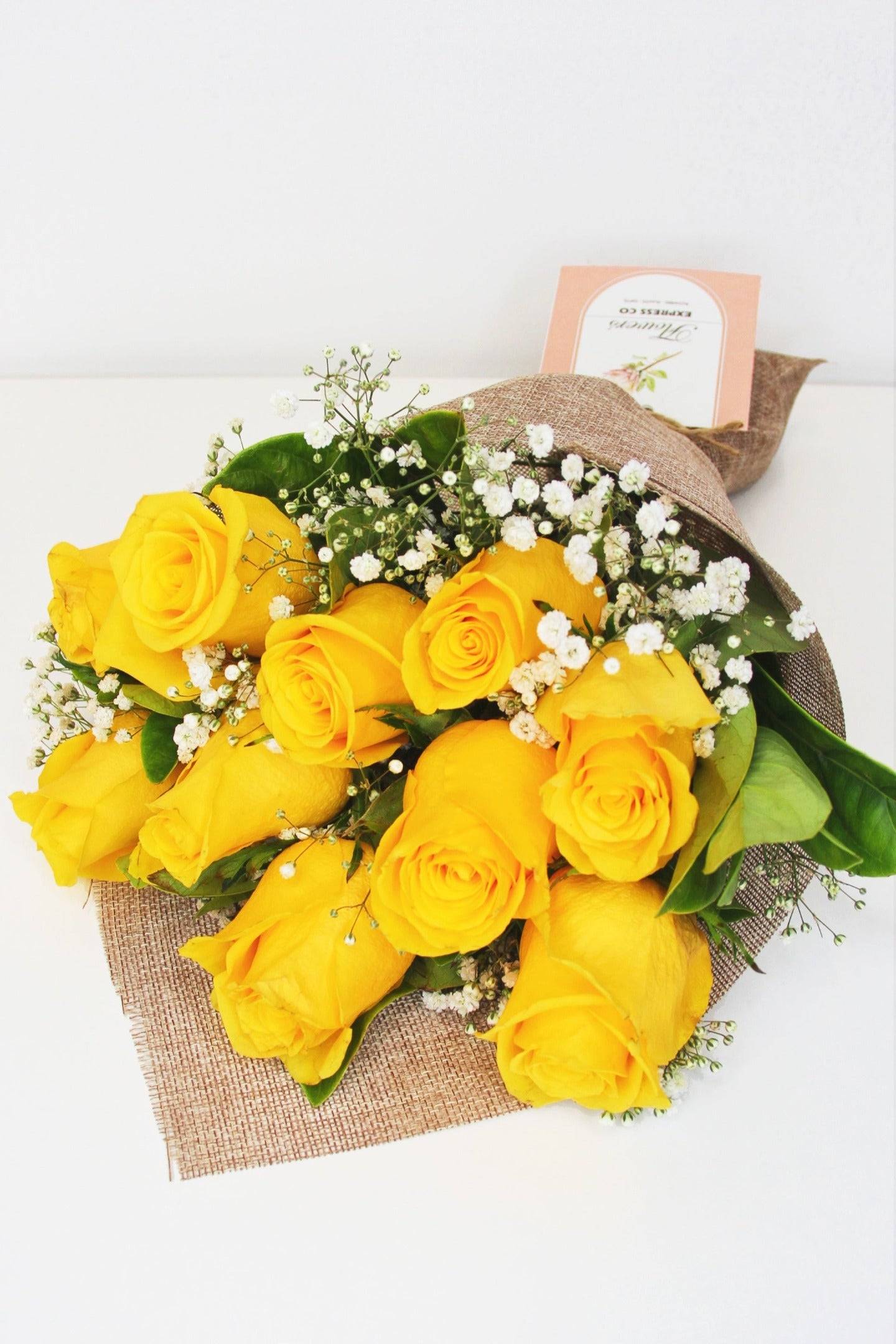 A bouquet of 10 yellow roses elegantly wrapped in a hessian-style mesh, available for delivery in Melbourne.
