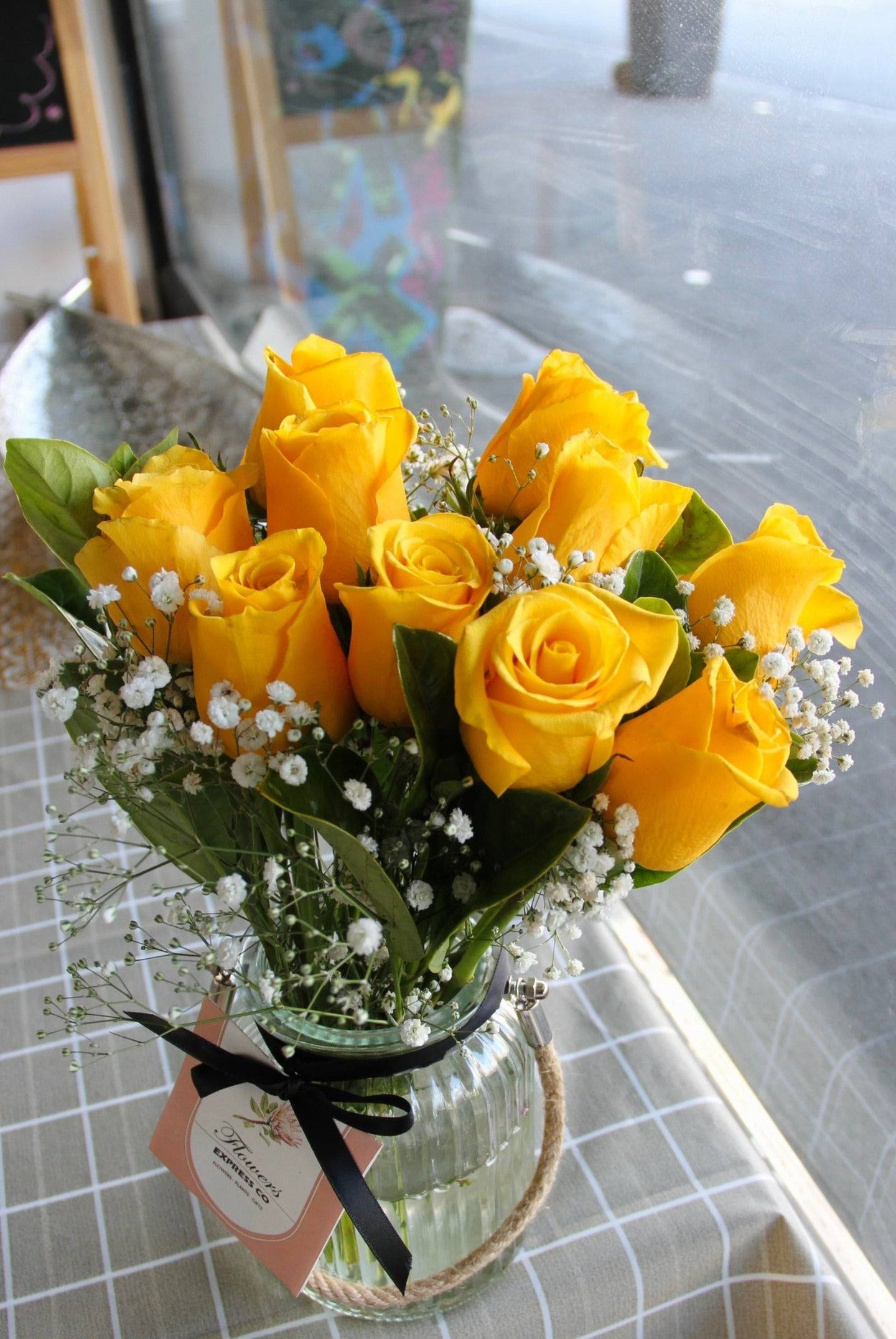 A bouquet of 10 yellow roses arranged in a glass jar, to be delivered in Melbourne.